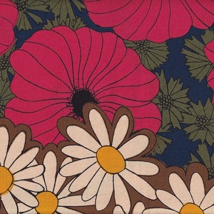 Peut inclure: Un tissu avec un motif floral rétro. De grandes fleurs roses vibrantes avec des centres noirs et des feuilles vertes se détachent sur un fond bleu foncé. La bordure inférieure présente des marguerites blanches avec des centres jaunes et des contours marron.