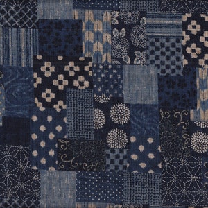 Könnte beinhalten: Ein Patchwork-Textil mit einer Vielzahl von blauen und beigen Mustern. Das Design umfasst florale, geometrische und gepunktete Motive, wodurch eine visuell strukturierte und detaillierte Oberfläche entsteht. Der Stoff ist wahrscheinlich Baumwolle oder Leinen.