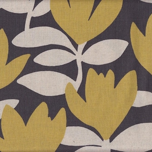 May include: Close-up of a fabric with a floral pattern. The design features large, stylized yellow flowers and white leaves against a dark gray background. The fabric has a textured appearance, suggesting a linen or similar material.