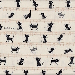 May include: A white fabric with a repeating pattern of black cats in various poses. The fabric has a musical note design printed on it. The text "CoCoLande" is printed on the fabric.