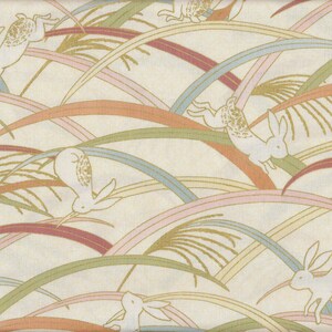 Könnte beinhalten: Cremefarbener Stoff mit einem sich wiederholenden Muster aus weißen Hasen, die über geschwungene Linien in Rosa, Orange, Grün und Blau springen. Das Design hat einen Vintage- und skurrilen Charakter, geeignet für Textilien oder Dekorationsartikel.