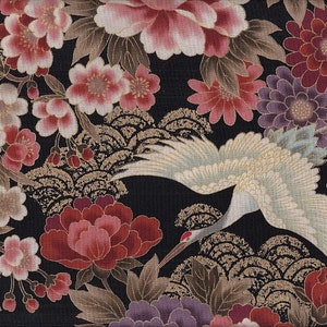 Könnte beinhalten: Schwarzer Stoff mit einem weißen Kranich, der über einem gold-schwarzen Wellenmuster fliegt. Der Stoff ist mit rosa, roten und violetten Blumen verziert.