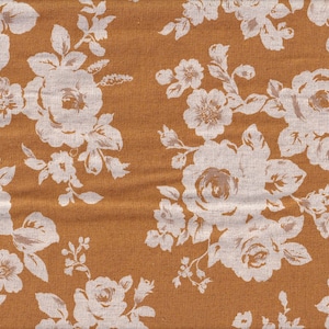 May include: A brown fabric with a white floral pattern. The fabric has a subtle texture and a repeating pattern of roses and leaves.