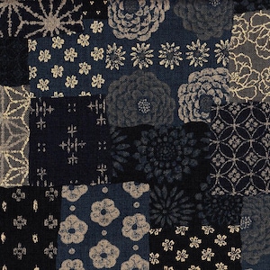 Puede incluir: Un textil de patchwork con diversos patrones geométricos y florales en tonos azul marino, dorado y gris. El diseño incluye flores estilizadas, explosiones de estrellas y formas geométricas, creando una composición texturizada y visualmente rica.