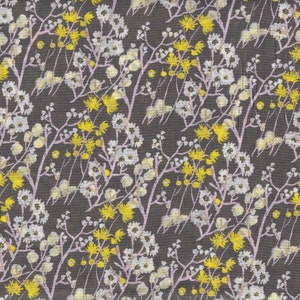 May include: A fabric with a repeating floral pattern. The design features white and yellow flowers with pink stems and leaves against a dark gray background. The flowers are clustered and create a dense, textured appearance.