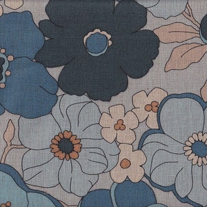 May include: A floral pattern featuring large, stylized flowers in shades of blue, gray, and peach. The design has a retro aesthetic, with the flowers outlined in dark lines. The fabric has a textured appearance, suggesting a woven material.