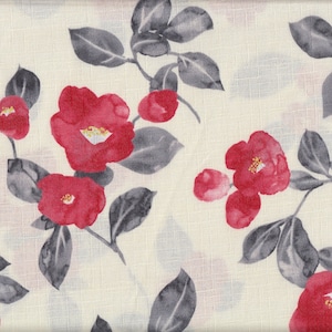 Könnte beinhalten: Cremefarbener Stoff mit einem sich wiederholenden Blumenmuster. Das Design zeigt leuchtend rote Kamelienblüten mit gelben Zentren und grauen Blättern. Der Stoff hat eine subtile Textur.