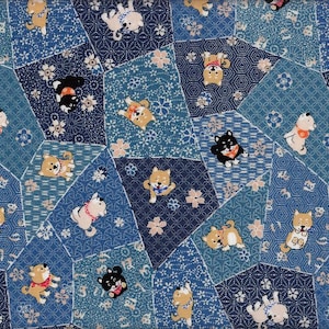 Op de afbeelding: Een patchworkpatroon in blauwtinten met Shiba Inu-honden in verschillende poses. De honden, in bruin, zwart en wit, dragen rode en roze halsbanden, tegen een achtergrond van bloemen- en geometrische patronen.