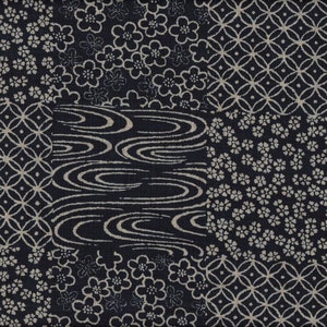 Könnte beinhalten: Ein Patchwork-Stoff mit dunkelblauem Hintergrund. Das Design zeigt verschiedene Muster in Off-White, darunter Blumen, geometrische Formen und wellenartige Motive. Der Stoff eignet sich für Quilt- oder Bastelprojekte.