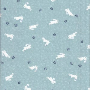 May include: A light blue fabric with a repeating pattern of white rabbits in various poses and small navy blue floral accents. The background has a subtle, tiny floral design.