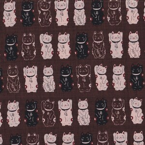 Op de afbeelding: Een herhalend patroon van gelukskat-illustraties in zwart, bruin en gebroken wit op een donkerbruine achtergrond. De katten zijn afgebeeld in een traditionele Japanse stijl, met opgeheven poten en decoratieve details.