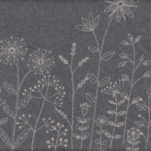 May include: A dark gray fabric with a floral design. White, delicate line drawings of various flowers and foliage are arranged across the fabric. The design includes detailed dandelions, leaves, and other floral elements.