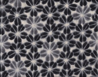 May include: Close-up of a fabric featuring a repeating floral design. The flowers are rendered in shades of grey and black, with a watercolour effect. The background is a light beige, and the fabric has a textured appearance.