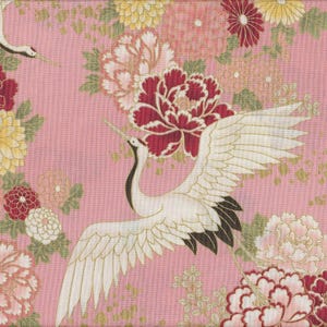 May include: Pink fabric with a Japanese floral and crane design. The fabric features white cranes with outstretched wings, surrounded by red, pink, and yellow flowers. The background is a soft pink.