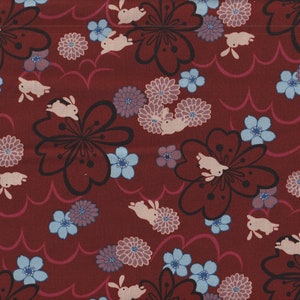 Könnte beinhalten: Burgunderfarbener Stoff mit einem sich wiederholenden Muster aus weißen Kaninchen, schwarz umrandeten Blumen, blauen und lila Blumen und rosa Wellenlinien. Das Design erinnert an eine japanische Ästhetik.