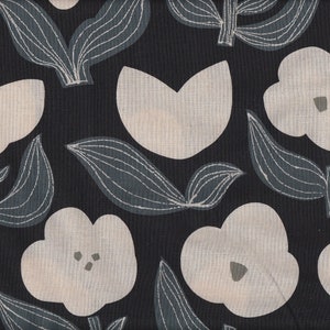 Peut inclure: Tissu noir avec un motif répétitif de fleurs stylisées blanches et de feuilles. Les fleurs ont une forme simple et arrondie et les feuilles sont longues et étroites.