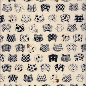 Op de afbeelding: Een witte stof met een herhalend patroon van zwarte kattengezichten. De kattengezichten zijn versierd met verschillende Japanse geïnspireerde patronen.