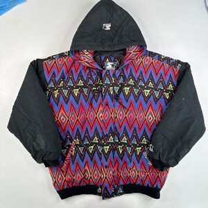 Könnte beinhalten: Eine schwarze und mehrfarbige Jacke der Marke Starter mit geometrischem Muster. Die Jacke hat eine Kapuze und einen Reißverschluss. Das Starter-Logo ist auf der linken Brust und dem rechten Ärmel sichtbar.