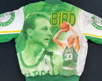 May include: A green and white bomber jacket featuring a portrait of Larry Bird and the word "BIRD" in yellow. The jacket has a green leaf pattern on the back and the Boston Celtics logo on the sleeves. The image of Larry Bird is in a Celtics jersey.
