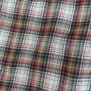 May include: A close-up of a brown, white, blue, and red plaid fabric. The fabric has a woven texture and is made of a soft, comfortable material.