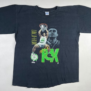 Op de afbeelding: Zwart T-shirt met een afbeelding van een basketballer, met de tekst "AUCK FOX" en "WINSTON".