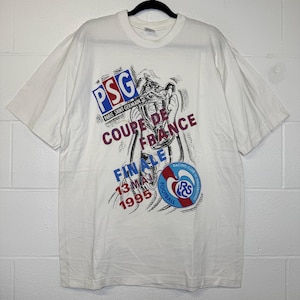 May include: White t-shirt featuring a graphic design commemorating the Coupe de France final. The design includes the PSG logo, the words "COUPE DE FRANCE FINALE 13 MAI 1995", and the Racing Club de Strasbourg logo. The shirt is short-sleeved.