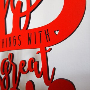 May include: Red wooden sign with the text "Do great things with a great heart" in black lettering. A small heart is cut out of the wood.