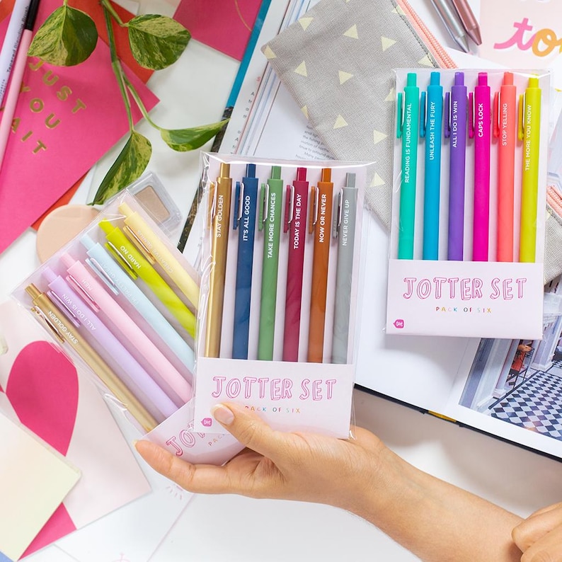 May include: Two sets of colorful pens with motivational quotes. The pens are packaged in clear plastic and labeled "Jotter Set, Pack of Six".