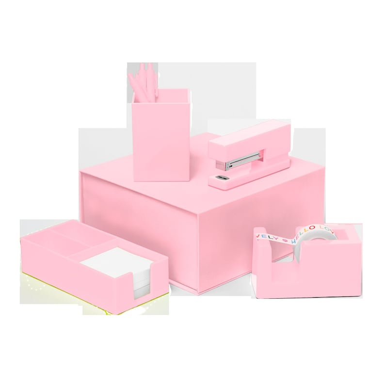 Blush Pink desk set including a stapler, tape dispenser, utility tray, and pen cup with three pink pens all stacked on top of a matching box.