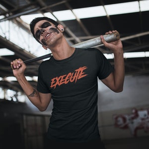 May include: A person wearing a black t-shirt with the word "EXECUTE" in orange lettering. The person is holding a baseball bat over their shoulder.