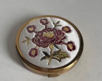 Cipria compatta con effetto floreale dorato