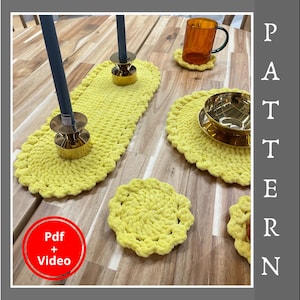 May include: A selection of handmade yellow crochet items, including a table runner, placemats, and coasters. The table is set with brass candle holders, a glass mug, and a gold bowl. A red circle with "Pdf + Video" is in the corner.