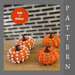 May include: Four crocheted orange pumpkins with dark brown stems. Two pumpkins are decorated with white beads, and two are decorated with metallic copper beads. An orange circle contains the text Pdf + Video, and the word PATTERN is vertical.
