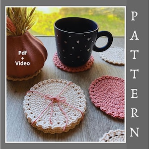 May include: A collection of handmade crochet coasters in various colors, including cream and pink, with a dark blue mug featuring star patterns. The coasters are arranged on a wooden surface, with the text "Pdf + Video" visible.