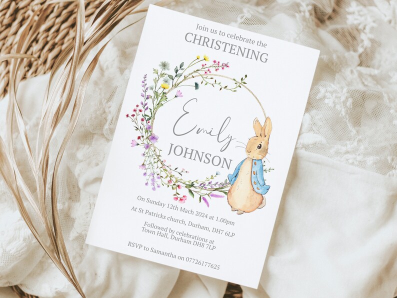 May include: A white card with a floral wreath and a bunny rabbit illustration. The text reads "Join us to celebrate the CHRISTENING Emily JOHNSON On Sunday 12th March 2024 at 1.00pm At St Patricks church, Durham, DH7 6LP Followed by celebrations at Town Hall, Durham DH8 7LP RSVP to Samantha on 07726177625"