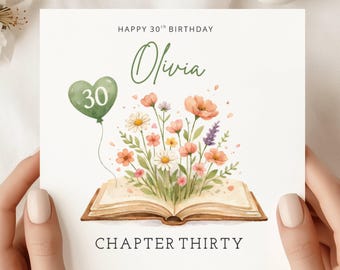 May include: A square birthday card with the text "Happy 30th Birthday Olivia". The card features a watercolour illustration of an open book with flowers and a green balloon with the number 30.