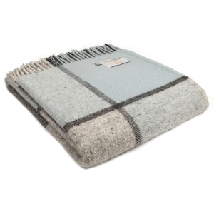 Könnte beinhalten: Eine weiche, blaue und graue karierte Wolldecke mit Fransen. Die Decke ist aus Wolle und hat ein gewebtes Etikett mit der Aufschrift "Tweedmill".