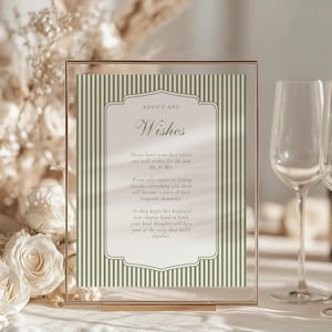 May include: A gold-framed sign with the words "ADVICE AND Wishes" in elegant script. The sign features a green and white striped background and includes text about sharing advice and well wishes for a new couple. Perfect for a wedding or bridal shower.