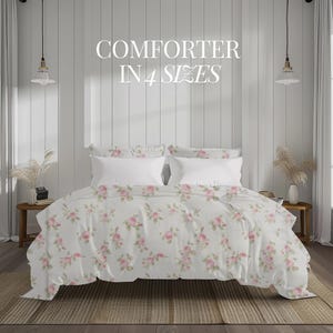 May include: A white comforter with a pink floral pattern on a bed with white pillowcases. The text "COMFORTER IN 4 SIZES" is displayed above the bed.