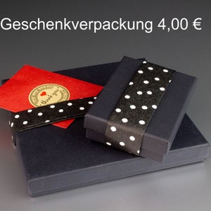 May include: A gift box set with a black box, a red card, and a black ribbon with white polka dots. The red card has a gold sticker with a heart and the words "thank you".