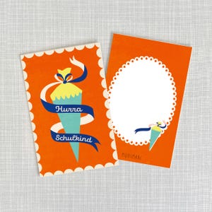 Könnte beinhalten: Zwei orangefarbene Karten mit weißen gewellten Rändern. Die linke Karte zeigt ein blaues und weißes Band mit dem Text "Hurra Schulkind" und eine Cartoon-Illustration eines blauen und gelben Schultüten. Die rechte Karte hat einen weißen Kreis mit einem gewellten Rand und den Text "Monimari" unten.