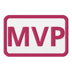 Op de afbeelding: Een roze rechthoekige patch met een witte rand en het woord "MVP" in roze letters.
