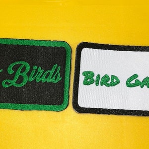 May include: Two embroidered patches with green lettering on black and white fabric. The first patch says "Go Birds" and the second patch says "Bird Gang".