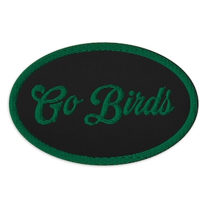 May include: Green and black embroidered oval patch with the text "Go Birds" in a cursive font.