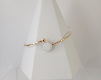 Golden ring bracelet and white concrete