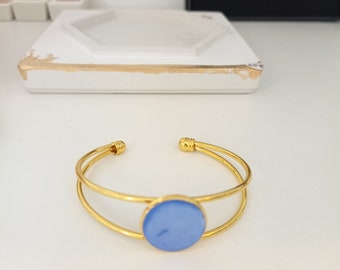 Golden steel bangle bracelet and pigmented blue concrete