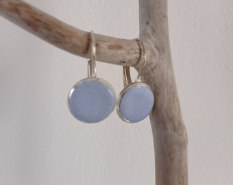 Silver earrings and blue concrete