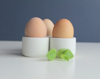 Set of three white concrete egg cups