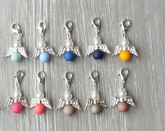 May include: Ten silver angel charms with different colored beads. The beads are light blue, dark blue, yellow, pink, red, brown, and gray.