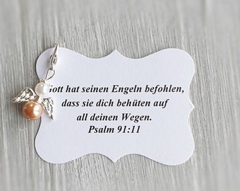May include: A white card with a silver angel charm attached. The card has the text "Gott hat seinen Engeln befohlen, dass sie dich behüten auf all deinen Wegen. Psalm 91:11" printed on it.